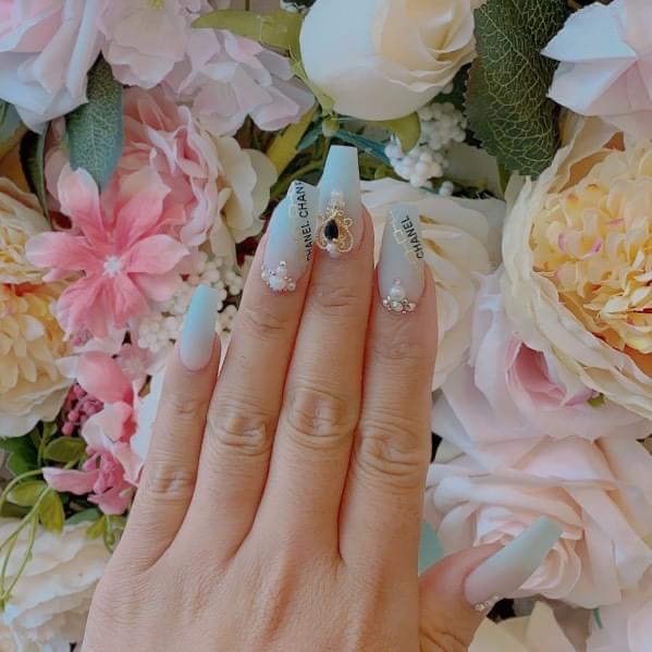 Pale blue almond nails with gold charms